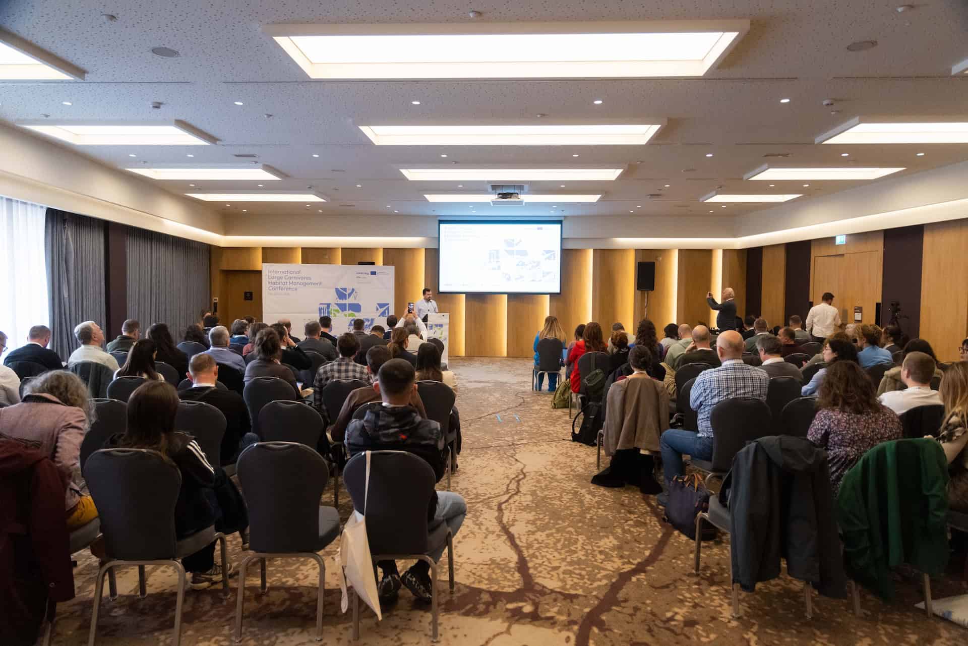 People seated and listening to a presentation during a meeting